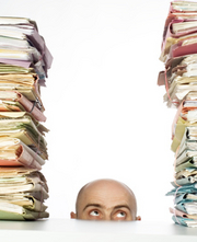 man looking up at stacks of files